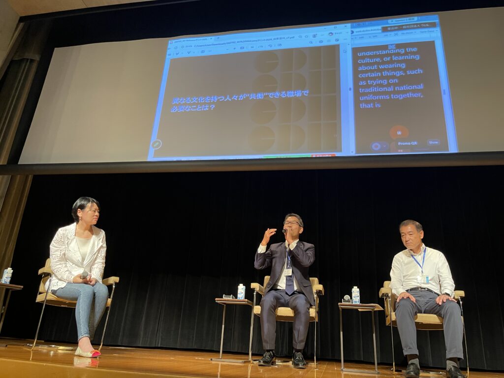 「異なる文化を持つ人々が共働できる職場で必要なこととは?」のスライドを背景にしたパネルディスカッション